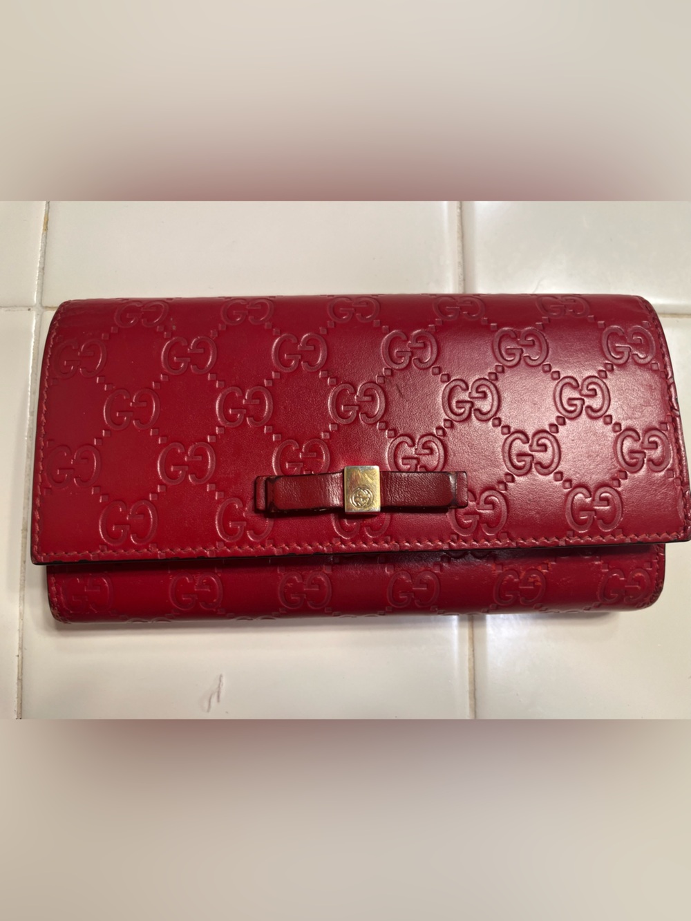 Gucci Guccissima Continental wallet with a bow detail and gold-tone